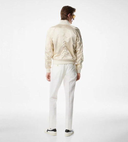 Person wearing a cream-colored jacket and pants on a white background