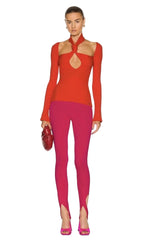 Woman wearing a red outfit with cut-out design on a white background