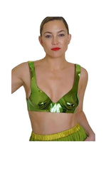 Person wearing a green sequined top and skirt against a plain background