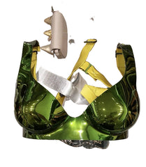 Shiny green handbag with yellow strap on a clear stand