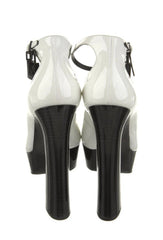 White high-heeled shoes with black soles on a white background