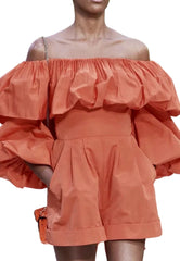 Coral off-shoulder dress with ruffled details on a white background