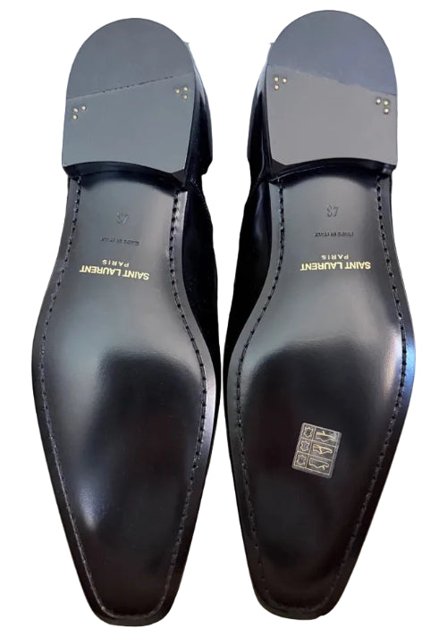 Black dress shoes with 'Saint Laurent' branding on a light gray surface.