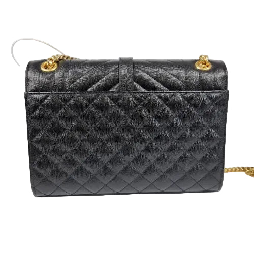 Black quilted handbag with gold accents on a white background