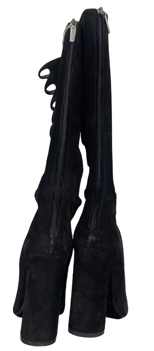 Pair of black leather riding boots with zippers on a light gray background
