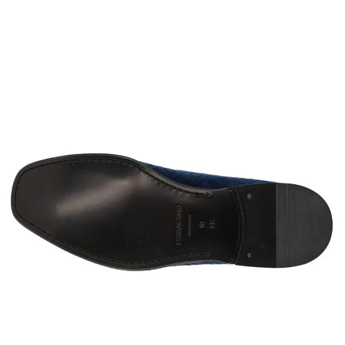 A close-up, top-down view of a shoe's black treaded outsole against a solid white background.