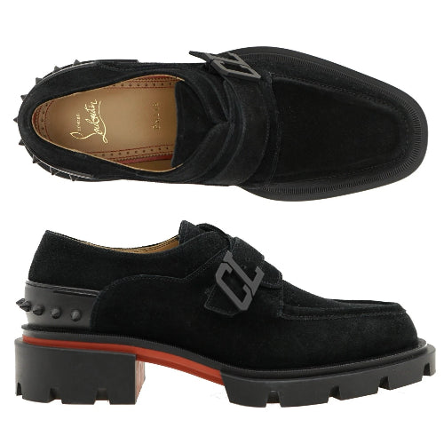 Black loafers with a buckle detail on a white background