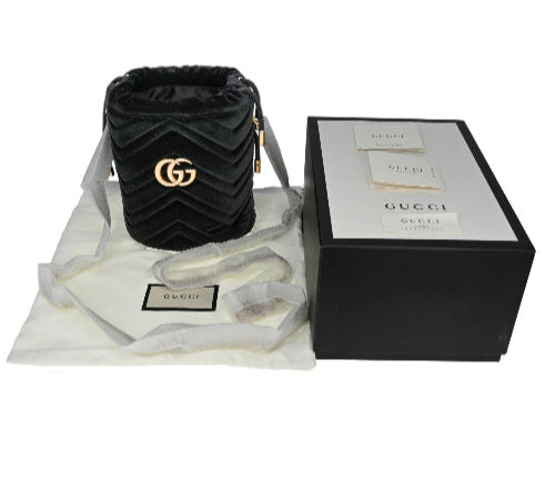 Black Gucci bag with packaging and accessories on a white background