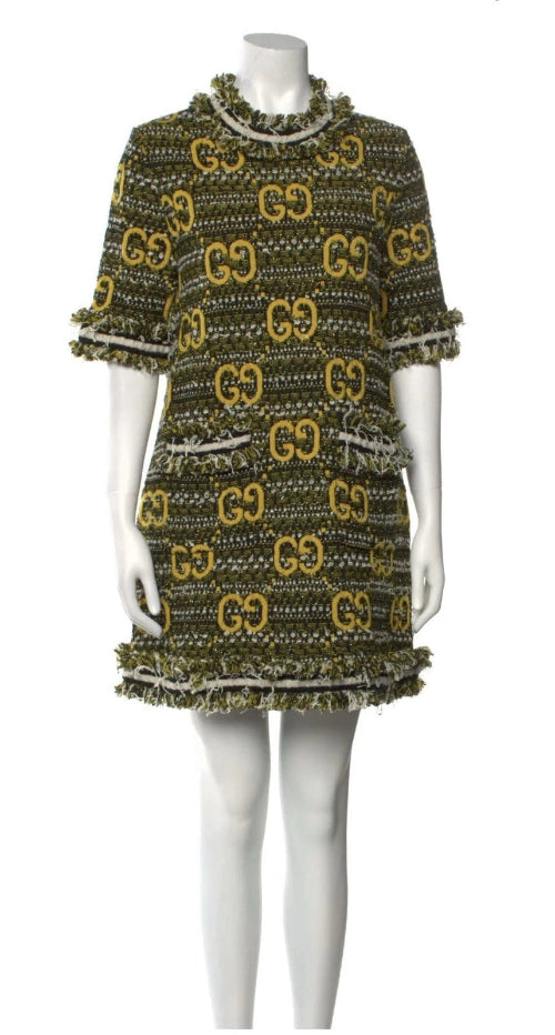 Green and gold patterned dress on a mannequin against a white background