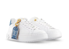 White sneaker with denim patch and gold button on a white background