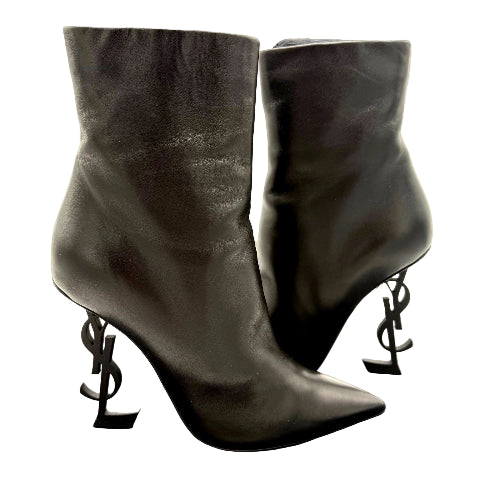 Pair of black high-heeled boots with unique heel designs on a white background