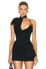 Woman wearing a black dress with a high neckline and draped design on a white background
