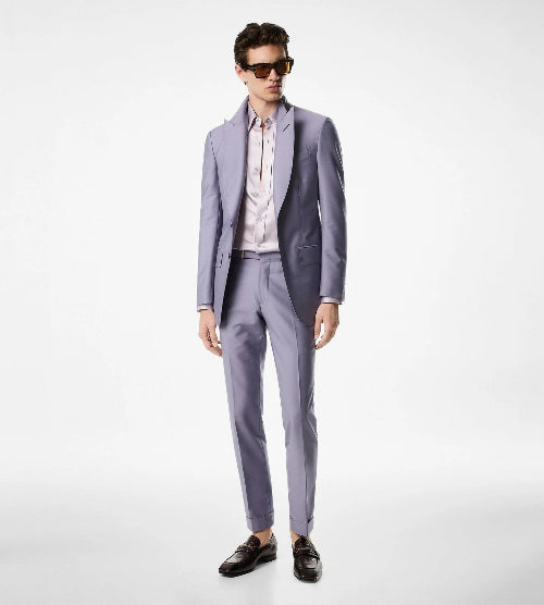 Man wearing a light gray suit with sunglasses on a white background