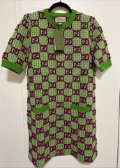 Green and purple patterned baby outfit on a hanger against a white background