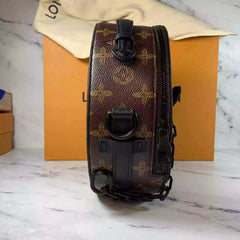 Designer handbag with monogram pattern on a marble surface with a branded box in the background.