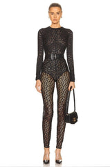 Person wearing a black lace top and leopard print pants with a white background