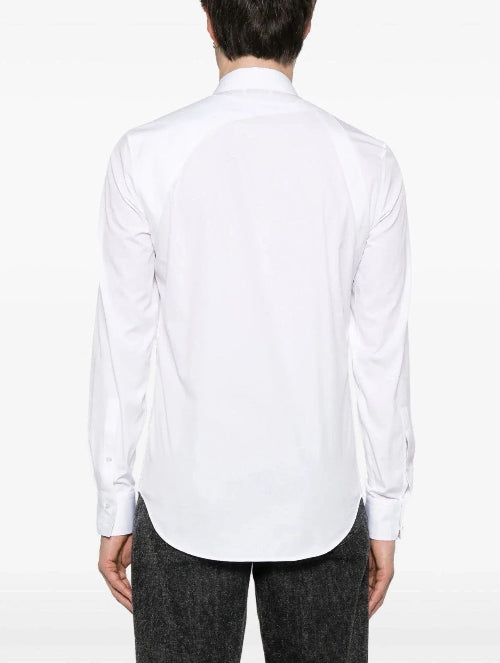 A man wearing a white long-sleeve button-down shirt and black trousers, shown from the back against a plain white background.