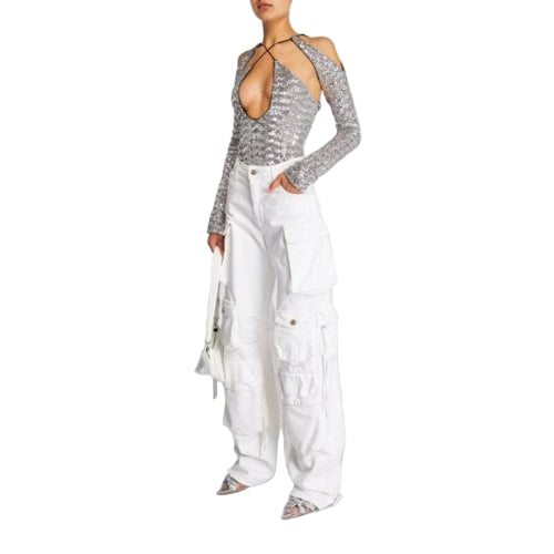 Person wearing a silver sequin top and white cargo pants on a light gray background
