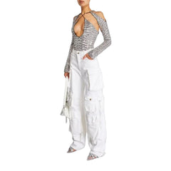 Person wearing a silver sequin top and white cargo pants on a light gray background