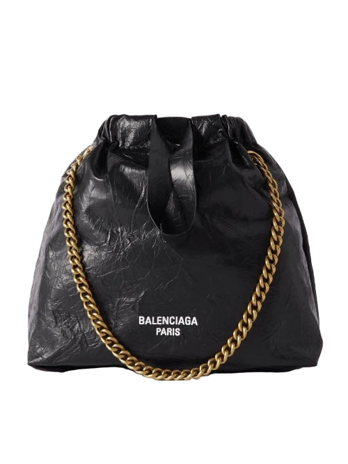 Black bag with gold chain and Balenciaga branding on a white background