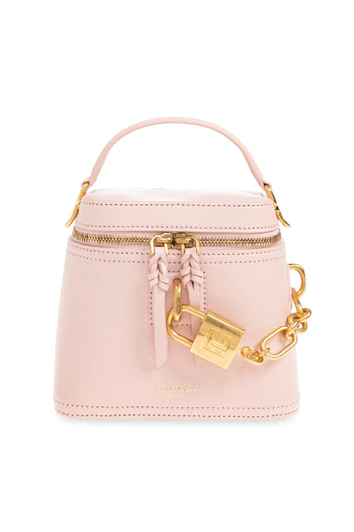 A light pink leather top-handle handbag with gold-tone hardware, featuring a zippered top, a hanging leather tassel, a decorative padlock charm, and a gold chain shoulder strap, shown on a plain white background.