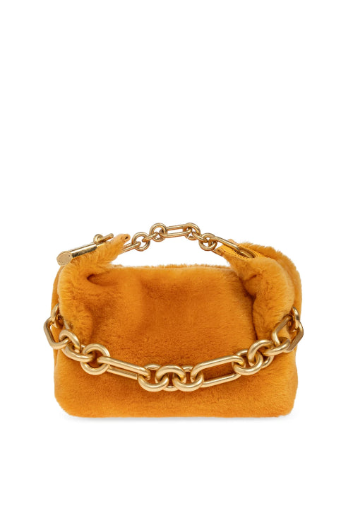 A small mustard yellow suede clutch bag with a gold chain strap, shown against a plain white background.