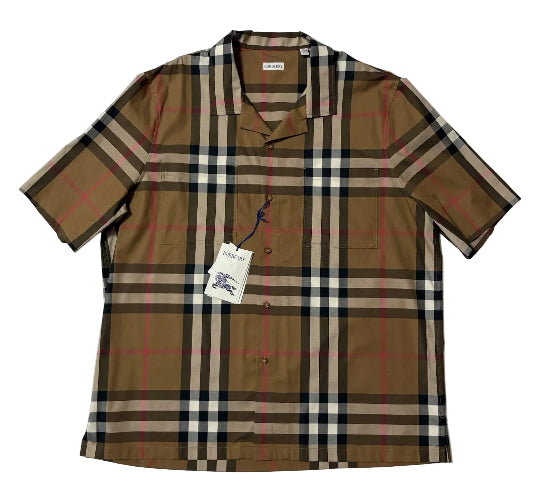 A short-sleeve Burberry plaid button-up shirt laid flat on a white background, featuring the classic tan, beige, black, and red check pattern with a visible hangtag.
