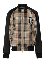A Burberry-style bomber jacket featuring a beige and black check plaid body with black sleeves and ribbed trim, plus a large embroidered 'TB' logo on the chest.