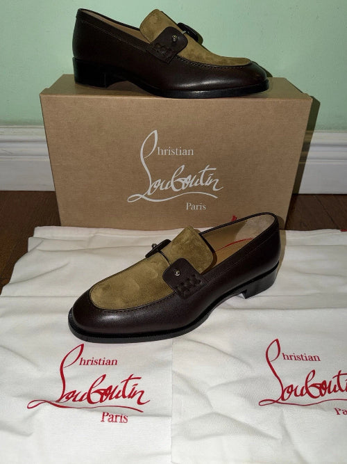 Christian Louboutin brown and tan suede loafers displayed with their brown cardboard shoebox and white dust bags featuring the red brand logo.