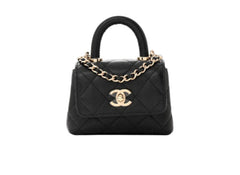 Black quilted Chanel handbag with gold chain and clasp on a white background
