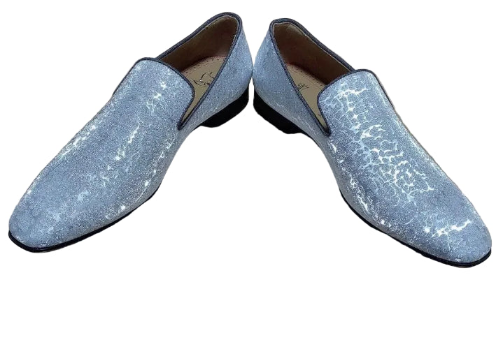 Silver glittery loafers on a brown box with 'Christian Louboutin' branding.