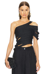 Woman wearing a black one-shoulder top with cut-out details and holding a matching clutch.