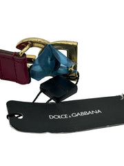 Dolce & Gabbana belt with red strap, gold buckle, and blue ribbon on a white background.