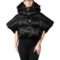 Person wearing a black puffer cape with button details on a white background