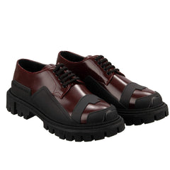Brown leather shoes with black soles on a white background