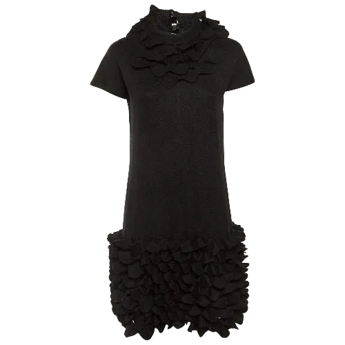 Black dress with ruffled details on a white background