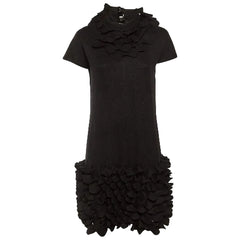 Black dress with ruffled details on a white background