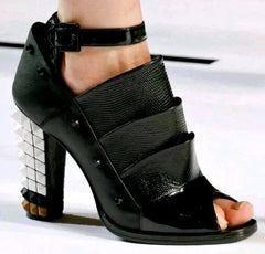 Black high-heeled sandal with open toe on a white background