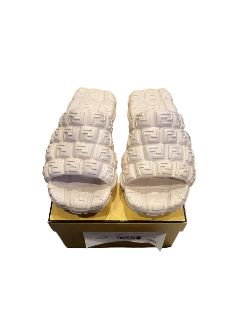 White slides with brand logo on a gold box on a gray floor.