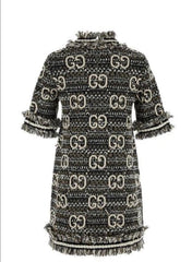 A Gucci tweed mini dress with an allover black and beige GG monogram pattern and fringed trim, shown against a plain white background.