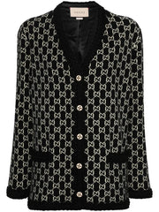 A Gucci black and beige GG monogram tweed cardigan with black fuzzy trim, buttoned front, and a visible Gucci label at the collar.