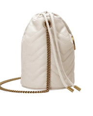 White quilted drawstring bag with gold chain on a light gray background
