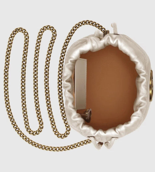 Decorative mirror with a gold chain on a light gray background
