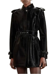 A black belted trench coat with a structured collar and front flap, shown on a model against a light beige background.