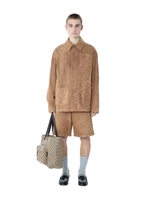 Person wearing a beige outfit with a matching bag on a white background