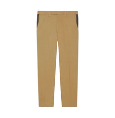 A pair of tan chinos with distinctive red and green striped side panels on the hips, shown flat against a white background.