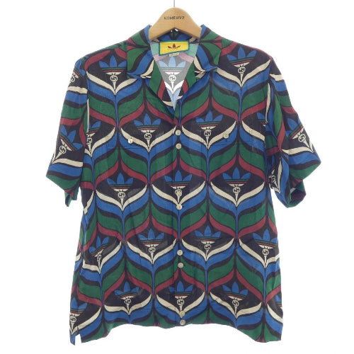 Colorful patterned shirt on a hanger with Adidas logo in the background