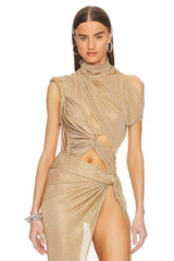 Woman wearing a gold dress with cut-out design on a white background