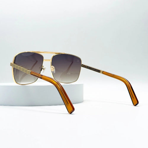 Sunglasses with gold frame and brown tortoiseshell arms on a light gray background