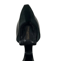 A close-up rear view of a black pointed-toe high-heeled shoe, showing a Louis Vuitton insole label on a plain white background.